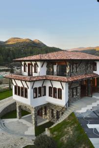 eine Darstellung eines Hauses mit Bergen im Hintergrund in der Unterkunft Pupa Winery Serene Stay in Berat