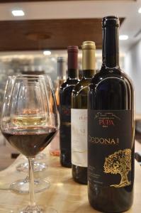 eine Flasche Wein neben einem Glas Wein in der Unterkunft Pupa Winery Serene Stay in Berat