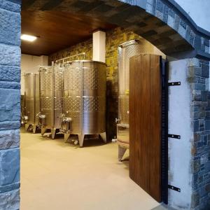 a row of wine barrels in a wine cellar at Pupa Winery Serene Stay in Berat