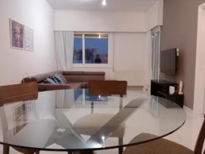 ein Wohnzimmer mit einem Glastisch und einem Sofa in der Unterkunft Zelea Deluxe Apartment (BREAKBOOKING CY) in Limassol