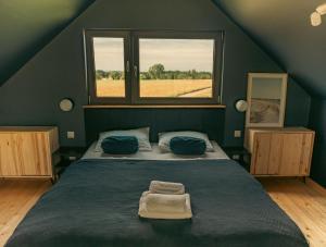 a bedroom with a large bed with a window at Żurawi Las in Sasino