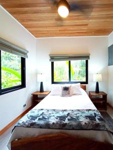 um quarto com uma cama grande e 2 janelas em Dragonfly Beach Retreat Beachfront Casitas-Adult Only em Punta Uva