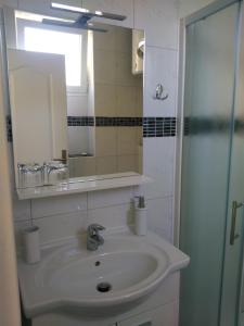 ein Bad mit einem Waschbecken und einem Spiegel in der Unterkunft Lemon house in Vis