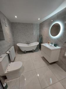 un bagno con vasca, WC e lavandino di Costa Glebe a Dungloe