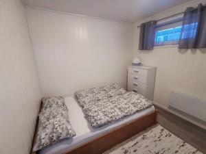 um pequeno quarto com uma cama e uma janela em Marta's Home-cozy appartment near the Airport em Andselv