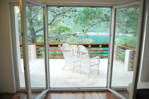 two chairs sitting on a patio with sliding glass doors at Hotel Art Media in Herceg-Novi