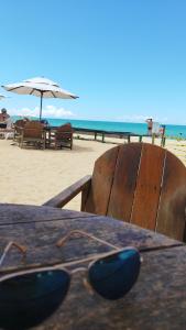 a table with a pair of glasses sitting at the beach at JL Temporadas - Quarto Portobello Park Hotel in Porto Seguro