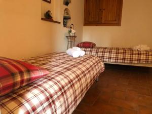 two beds in a room with plaid sheets at LA GROTTA in Subiaco