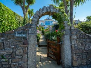 a stone wall with a gate in front of a house at Polgew Studio in Marazion