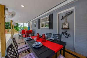 a table and chairs on a porch with a red napkin at Bama Cottage in Tuscaloosa