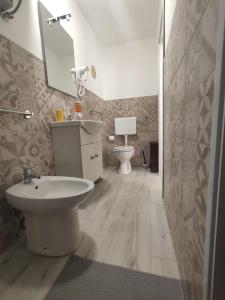 a bathroom with a sink and a toilet and a mirror at Casta Diva Holiday Rooms in Catania