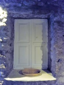 une porte dans un mur en pierre avec un bol devant dans l'établissement Artemis Studio Pyrgi, à Mykonos