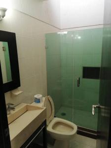 a bathroom with a toilet and a glass shower at Casa Cerca estadio Akron y plaza del sol in Guadalajara