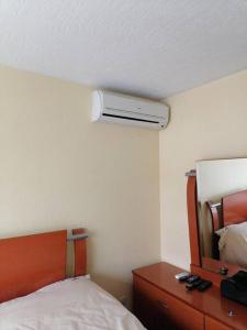 1 dormitorio con 1 cama y vestidor con ventilador en Casa Cerca estadio Akron y plaza del sol, en Guadalajara