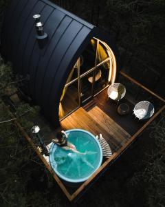 a person in a tub on a boat with a tent at Jungle SPA bungalows in Žocenes Ciems