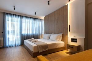 a bedroom with a bed and a large window at A&N Athens Luxury Apartments - Ermou in Athens
