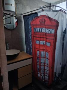 a bathroom with a red telephone booth shower curtain at Casa 2 recámaras in Mexico City