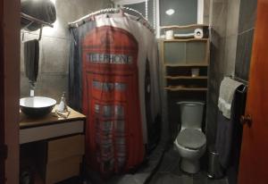 a bathroom with a red shower curtain and a toilet at Casa 2 recámaras in Mexico City