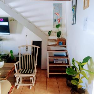 een woonkamer met een stoel en een trap bij Zagorski’s Bed and breakfast in Bloubergstrand