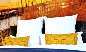 un letto con cuscini bianchi e gialli di ELBQUARTIER | Ferienwohnung in Wedel a Wedel