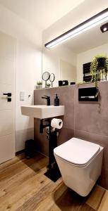 bagno con servizi igienici bianchi e lavandino di ELBQUARTIER | Ferienwohnung in Wedel a Wedel