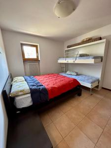 een slaapkamer met een bed met een rode en blauwe deken bij Appartamento di Montagna a Polsa Brentonico in Prada