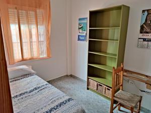 a bedroom with a bed and a book shelf at Centro Isla Cristina in Isla Cristina