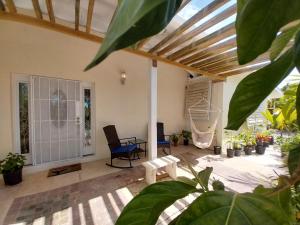 a living room with a table and chairs and plants at Private Guest House 2 bedrooms & 2 baths near Grace Bay Beach & Long Bay Beach. in Providenciales