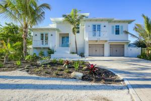 a white house with palm trees and a driveway at Beach Fanta Sea in Sarasota