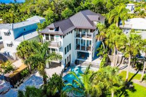 uma vista aérea de uma casa com piscina e palmeiras em The Shore House em Bailey Hall
