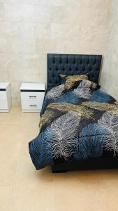 una camera con letto e copriletto blu e dorato di شقق الياسمين a Jerash