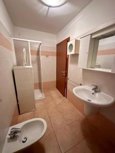 a bathroom with two sinks and a shower at Appartamento di Montagna a Polsa Brentonico in Prada