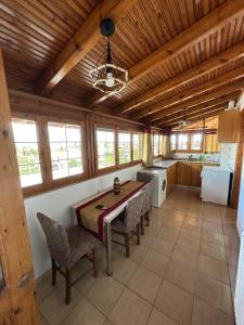 a kitchen with a wooden ceiling with a table and chairs at Bratis House 2 in Vartholomio