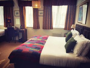 een slaapkamer met een groot bed en een kleurrijke deken bij The Robin Hill in Torquay