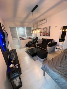 sala de estar con sofá y TV en Apartman Paola - massage chair- 0-24 self check IN OUT- Županja en Županja