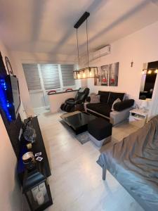 a living room with a couch and a tv at Apartman Paola - massage chair- 0-24 self check IN OUT- Županja in Županja