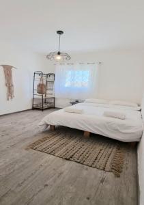 a white bedroom with a large bed and a rug at bloom in Eilat