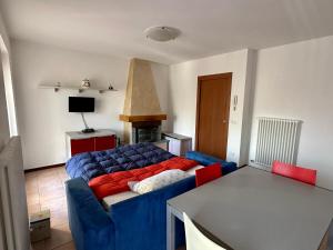 un soggiorno con divano blu e tavolo di Appartamento di Montagna a Polsa Brentonico a Prada