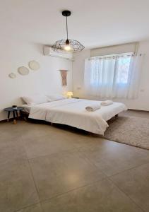 Un dormitorio blanco con una cama grande y una ventana en bloom en Eilat