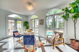 a living room with a table and chairs and windows at John Ringling House in Sarasota