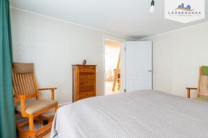 a bedroom with a bed and a chair and a door at Promenaadi apartament in Haapsalu