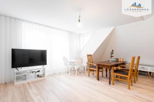 - un salon avec une table à manger et une télévision dans l'établissement Promenaadi apartament, à Haapsalu