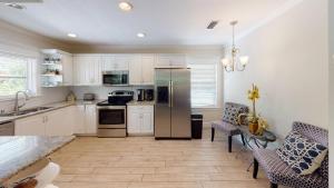 a kitchen with white cabinets and a stainless steel refrigerator at Lazy Days in Sarasota