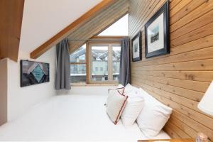 ein Schlafzimmer mit einem großen Fenster und weißen Kissen in der Unterkunft Fitzsimmons B - Private Sauna, Located in the Heart of Whistler Village in Whistler