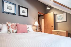 a bedroom with a large white bed and a staircase at Fitzsimmons B - Private Sauna, Located in the Heart of Whistler Village in Whistler +9 photos