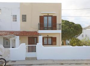 una casa con una cerca blanca delante de ella en Mesaria House Syros, en Ermoupoli
