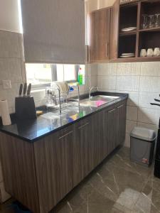 a kitchen with a sink and a counter top at Peaceful Hills Self Catering Holiday House in Lusaka