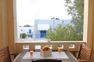 uma mesa com uma caixa de frutas numa varanda em Mesaria House Syros em Ermoupoli