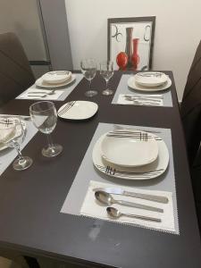 a black table with white plates and silverware on it at Peaceful Hills Self Catering Holiday House in Lusaka