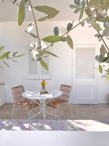 una mesa y sillas en una habitación con un mural en un árbol en At the Seacily, en Fontane Bianche